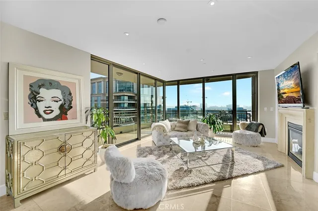 a living room with fireplace furniture and a large window