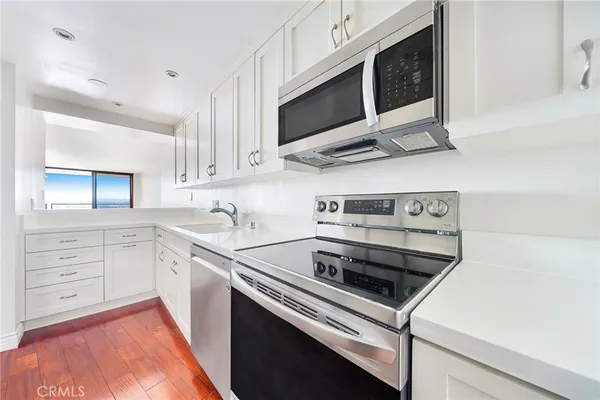 a kitchen with cabinets stainless steel appliances and sink
