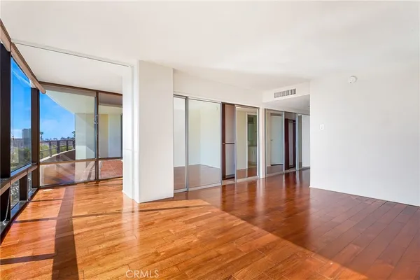 a view of a livingroom with wooden floor and furniture