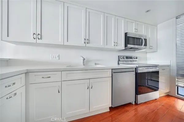 a kitchen with white cabinets and white appliances