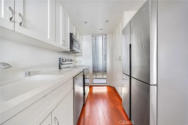 a kitchen with stainless steel appliances a refrigerator sink and cabinets