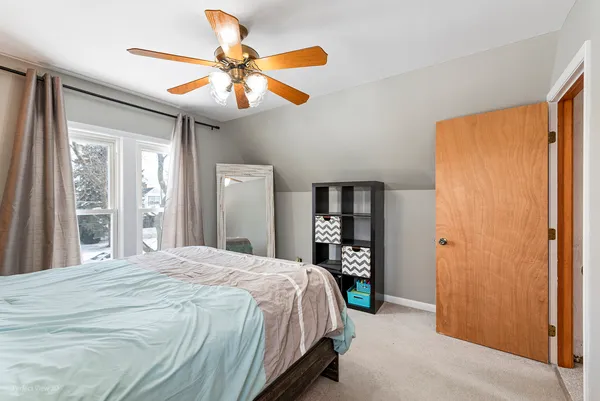 a bedroom with a large bed and a chandelier