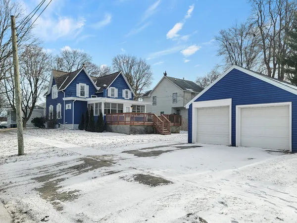 a front view of a house with a yard covered in snow