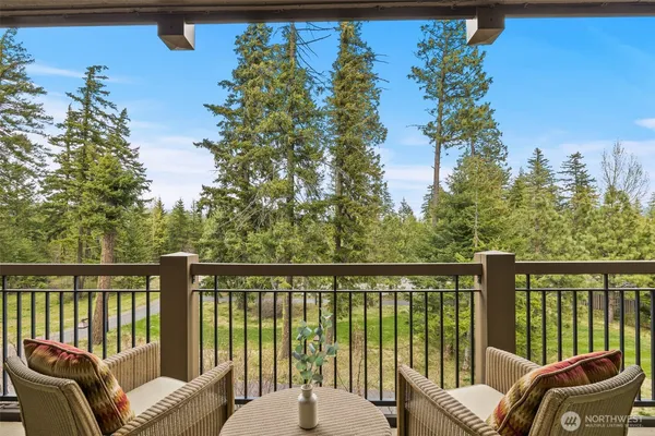 a balcony with wooden floor table and chairs