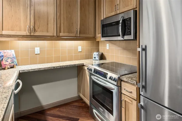 a kitchen with granite countertop a stove and a microwave