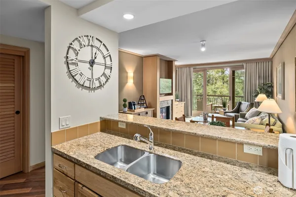 a kitchen with a stove a sink and a granite counter tops with white cabinets