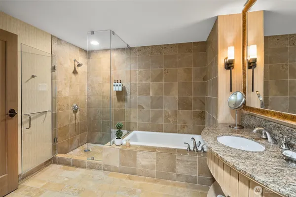 a bathroom with a granite countertop tub sink and shower