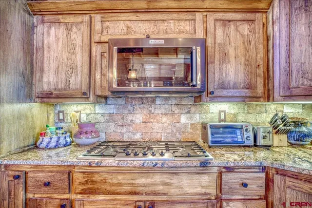 a kitchen with granite countertop cabinets and wooden floor