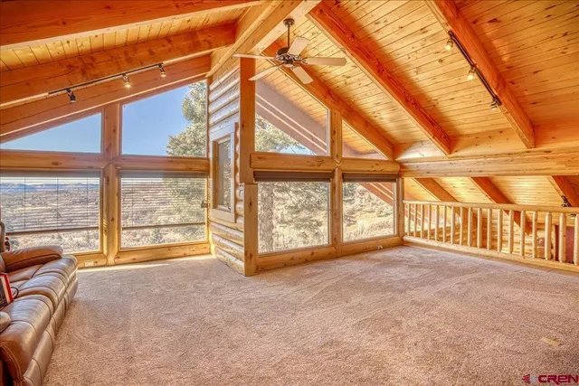 an empty room with large windows and couch