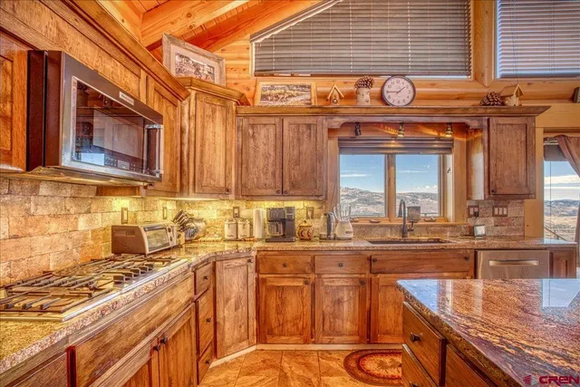 a kitchen with stainless steel appliances granite countertop a stove and a microwave