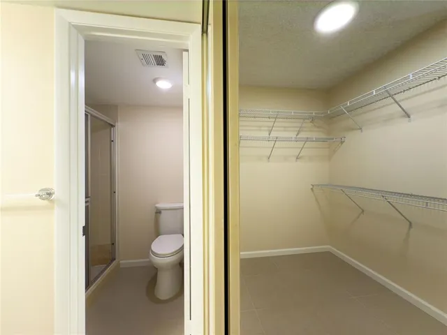 a white toilet sitting next to a shower