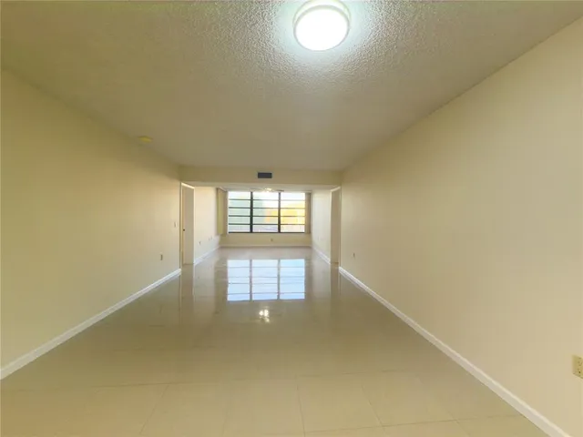 an empty room with windows and ceiling fan