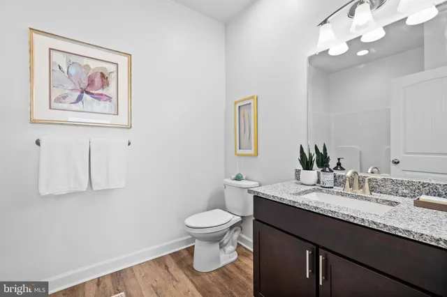 a bathroom with a granite countertop sink a toilet and a mirror