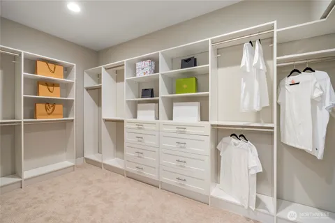 a view of walk in closet with clothes and shoes
