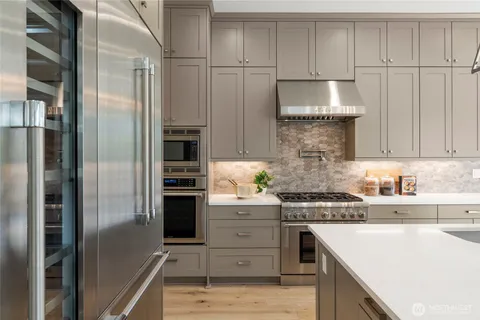 a kitchen with a refrigerator and a stove top oven