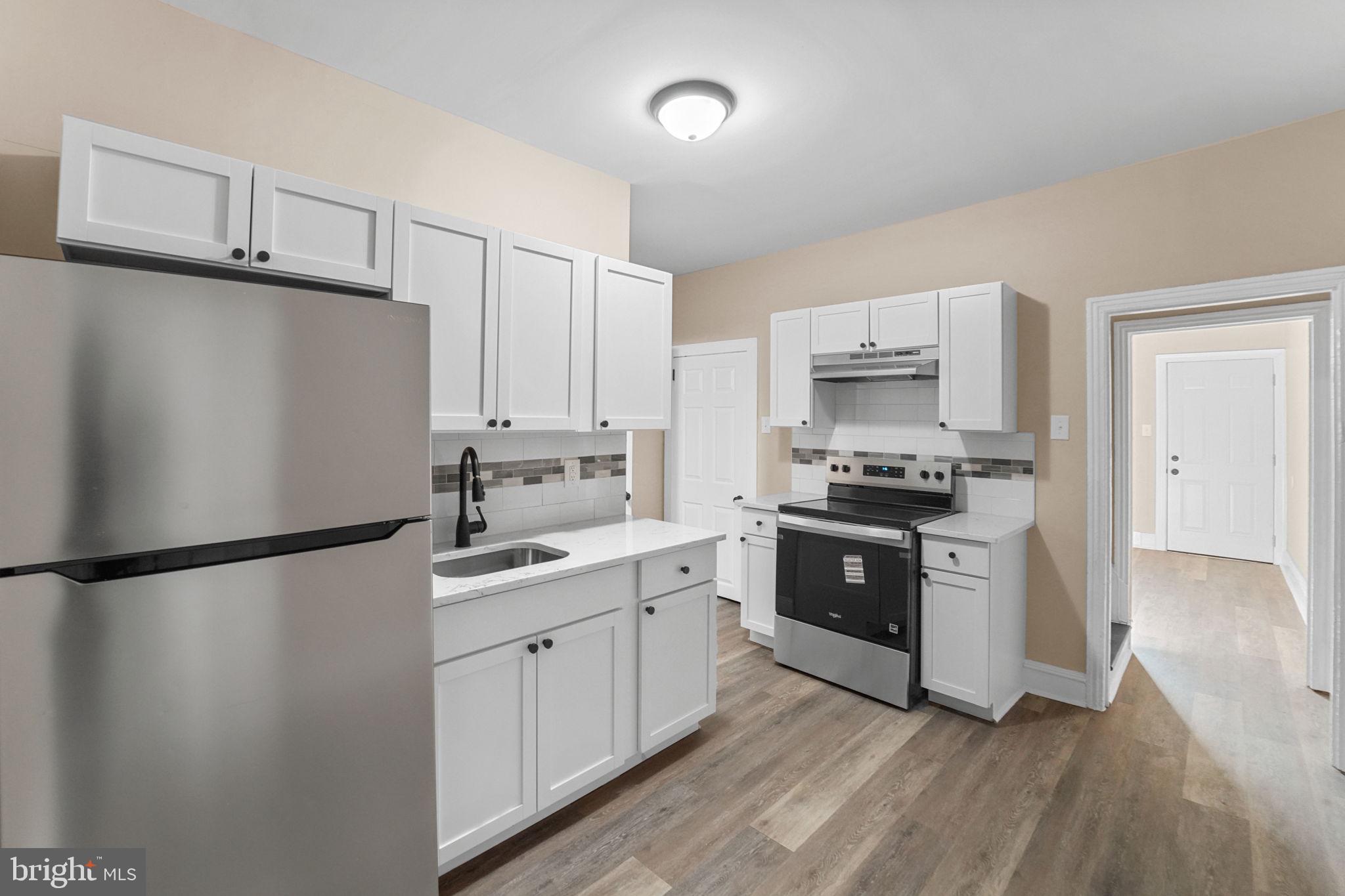 237 Morris Street Gloucester City, NJ 08030 - Photo 13 of 44 a kitchen with a sink a refrigerator and white cabinets