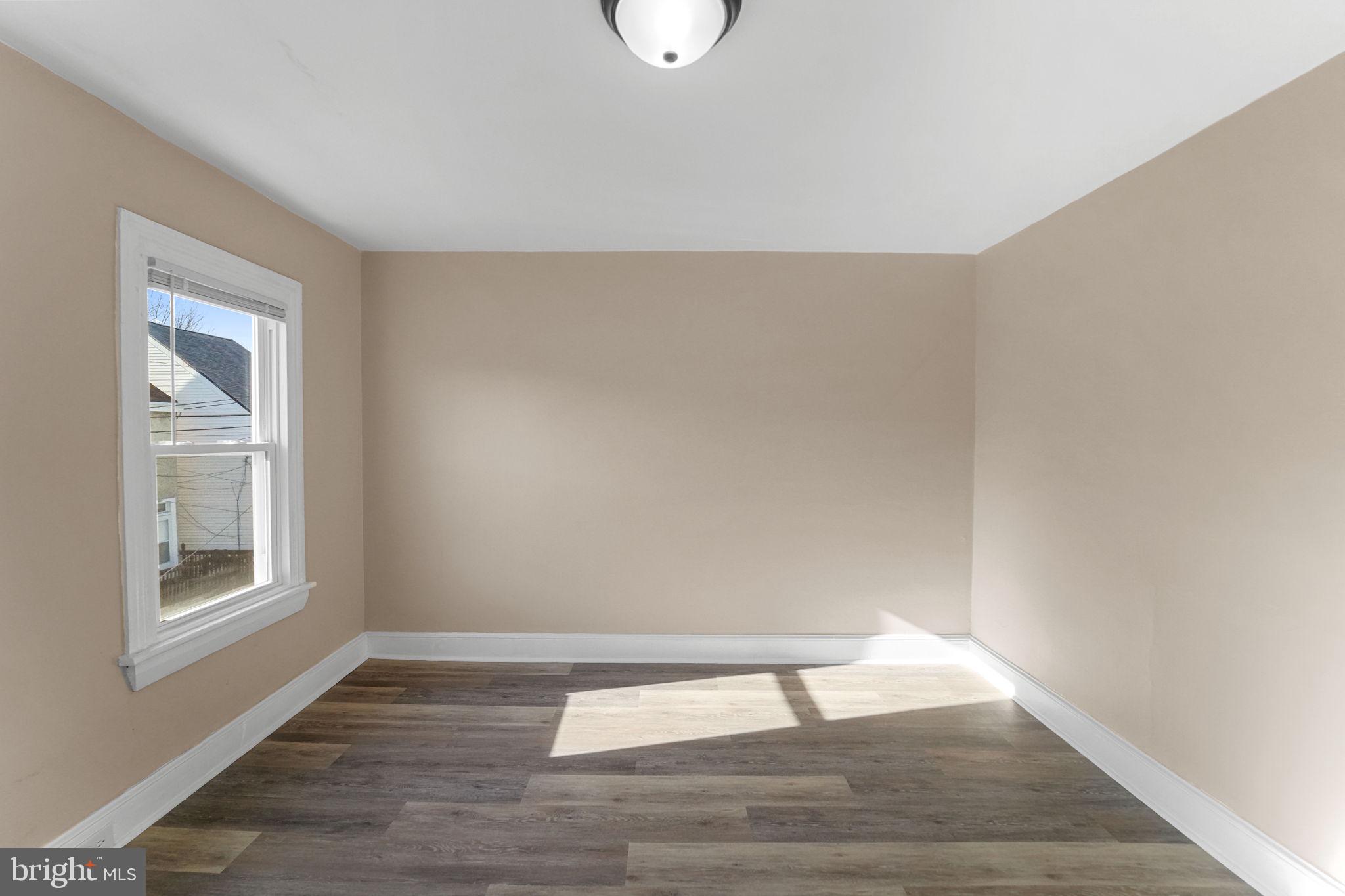 237 Morris Street Gloucester City, NJ 08030 - Photo 30 of 44 a view of an empty room with wooden floor and a window