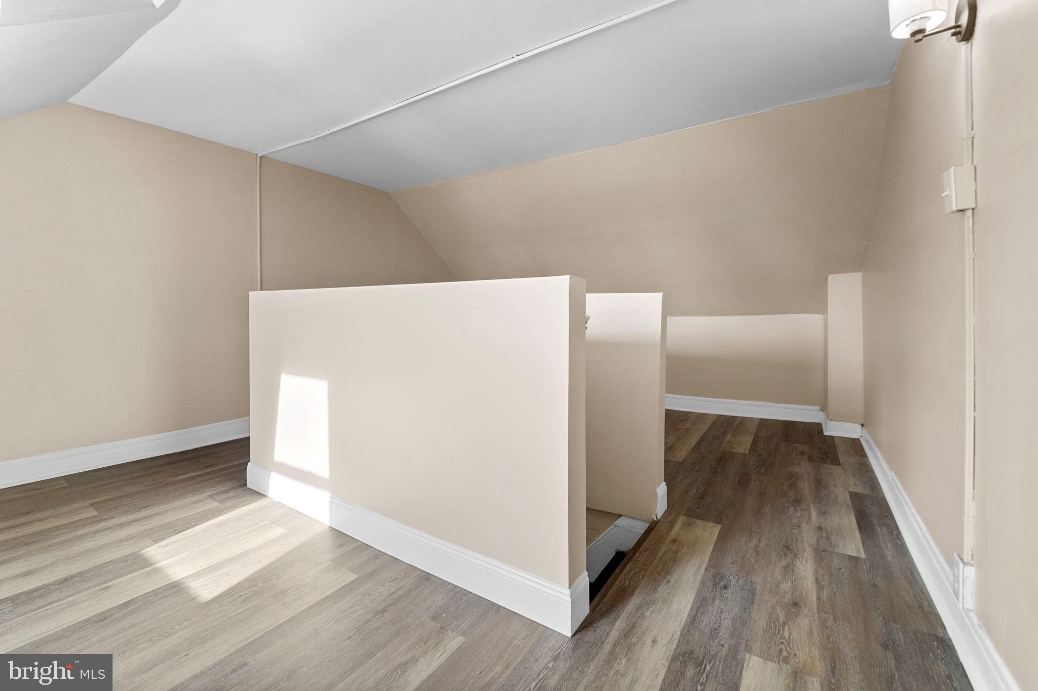 237 Morris Street Gloucester City, NJ 08030 - Photo 36 of 44 a view of a refrigerator in kitchen and an empty room with wooden floor