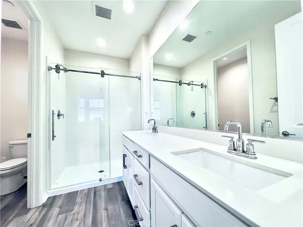 a spacious bathroom with a shower sink vanity mirror and toilet