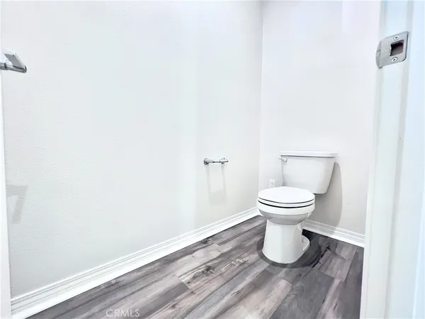 a white toilet sitting next to a white cabinet