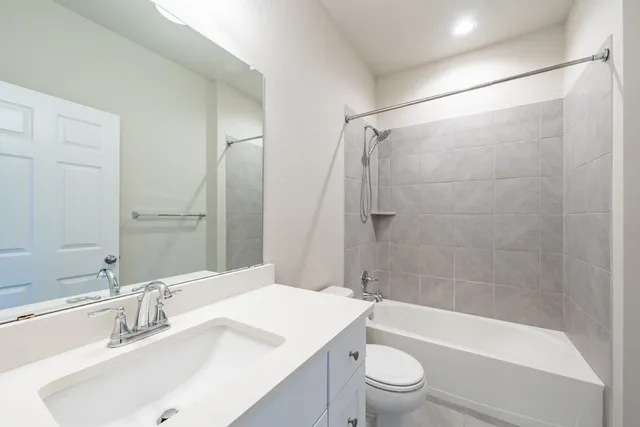a bathroom with a sink a toilet and a large mirror