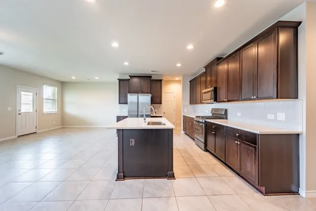 a large kitchen with stainless steel appliances granite countertop a large counter top and a stove top oven