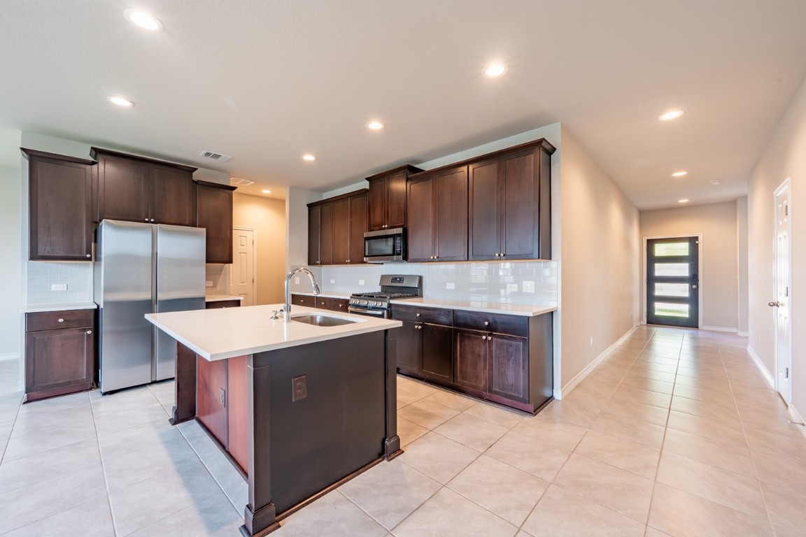 1325 Eagle Ray Street Leander, TX 78641 - Photo 5 of 16 a large kitchen with stainless steel appliances granite countertop a stove a refrigerator a sink a oven and a refrigerator