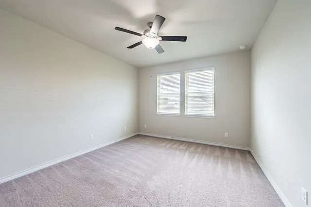 an empty room with a window and a fan