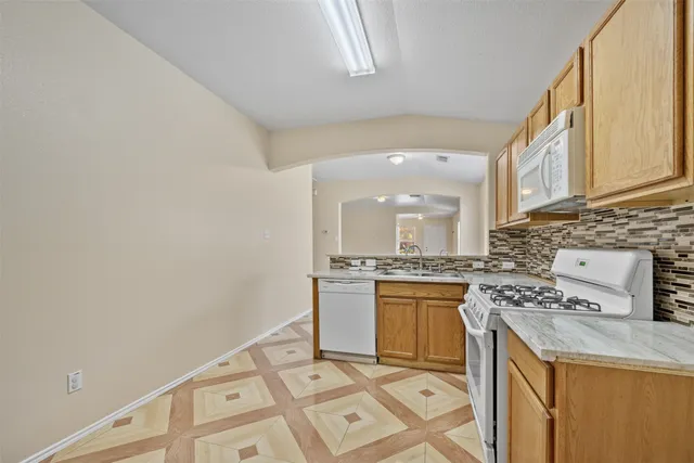 a large kitchen with granite countertop a sink and cabinets