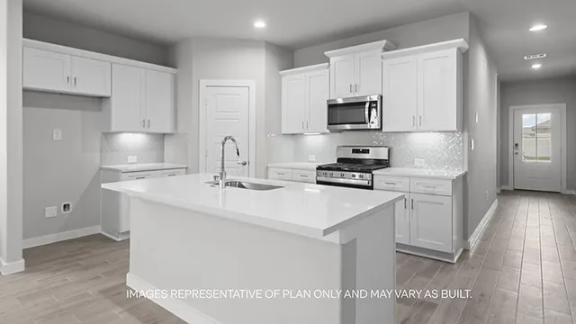 a kitchen with stainless steel appliances a sink stove refrigerator and cabinets