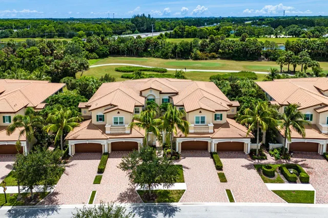 an aerial view of a houses with a garden and lake view