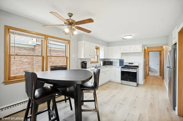 a kitchen with a table chairs refrigerator and cabinets