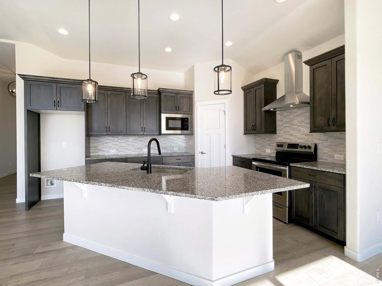 1145 Bitterroot Court Johnstown, CO 80534 - Photo 3 of 31 a kitchen with stainless steel appliances granite countertop a sink a refrigerator and a microwave