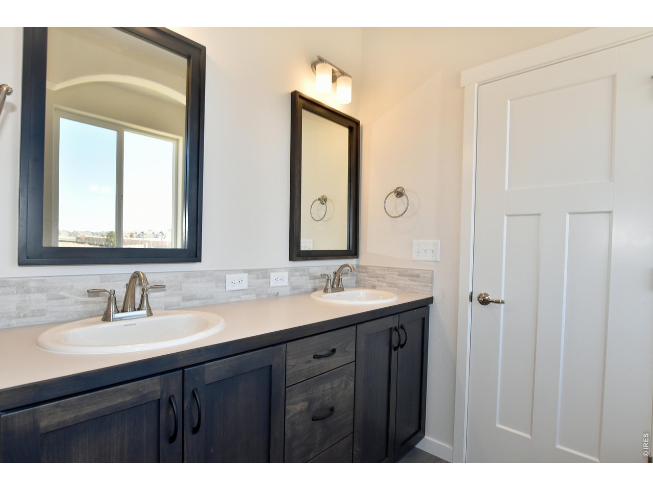 1145 Bitterroot Court Johnstown, CO 80534 - Photo 31 of 31 a bathroom with a double vanity sink and a mirror