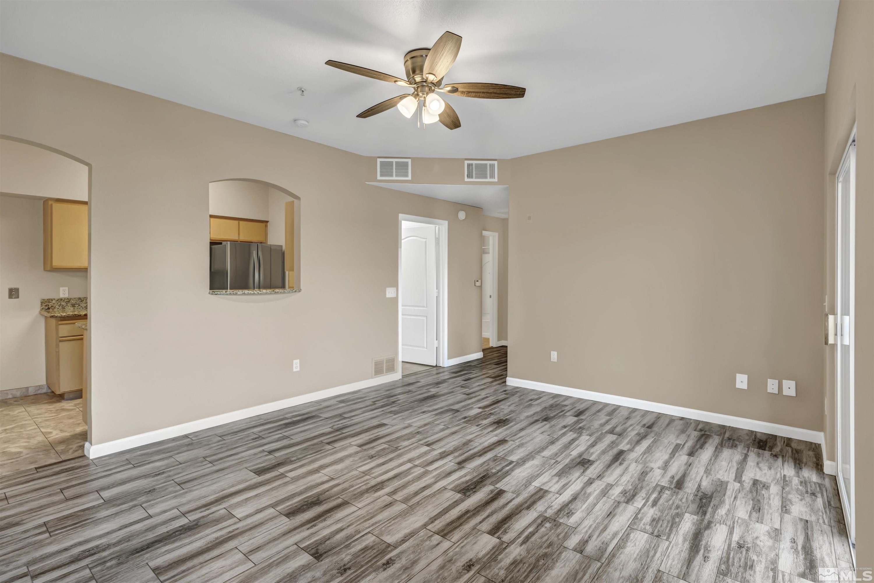 6850 Sharlands Avenue, Unit 1036 Reno, NV 89523 - Photo 3 of 36 a view of an empty room with window and wooden floor