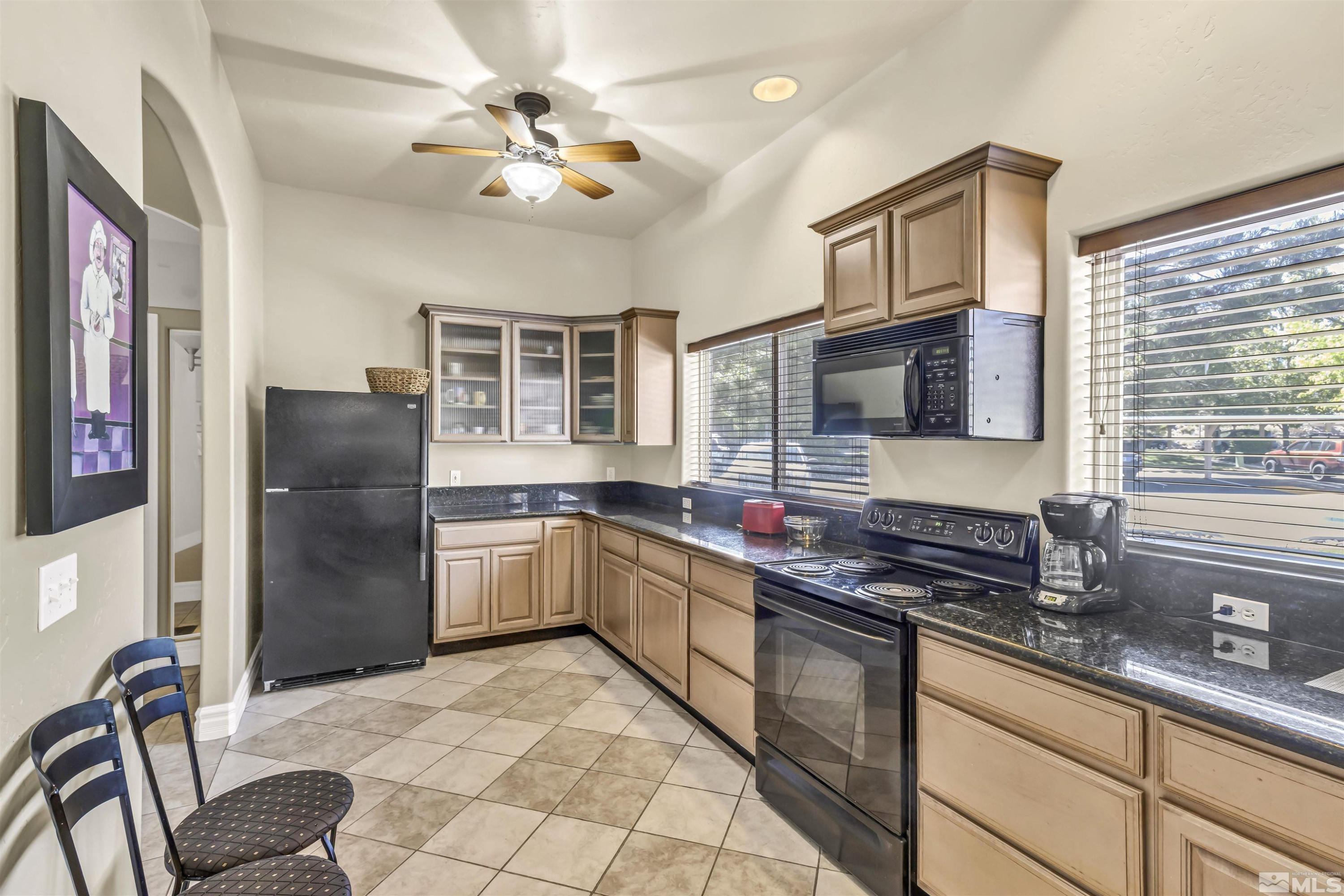 6850 Sharlands Avenue, Unit 1036 Reno, NV 89523 - Photo 34 of 36 a kitchen with stainless steel appliances granite countertop a stove top oven a sink a dining table and chairs