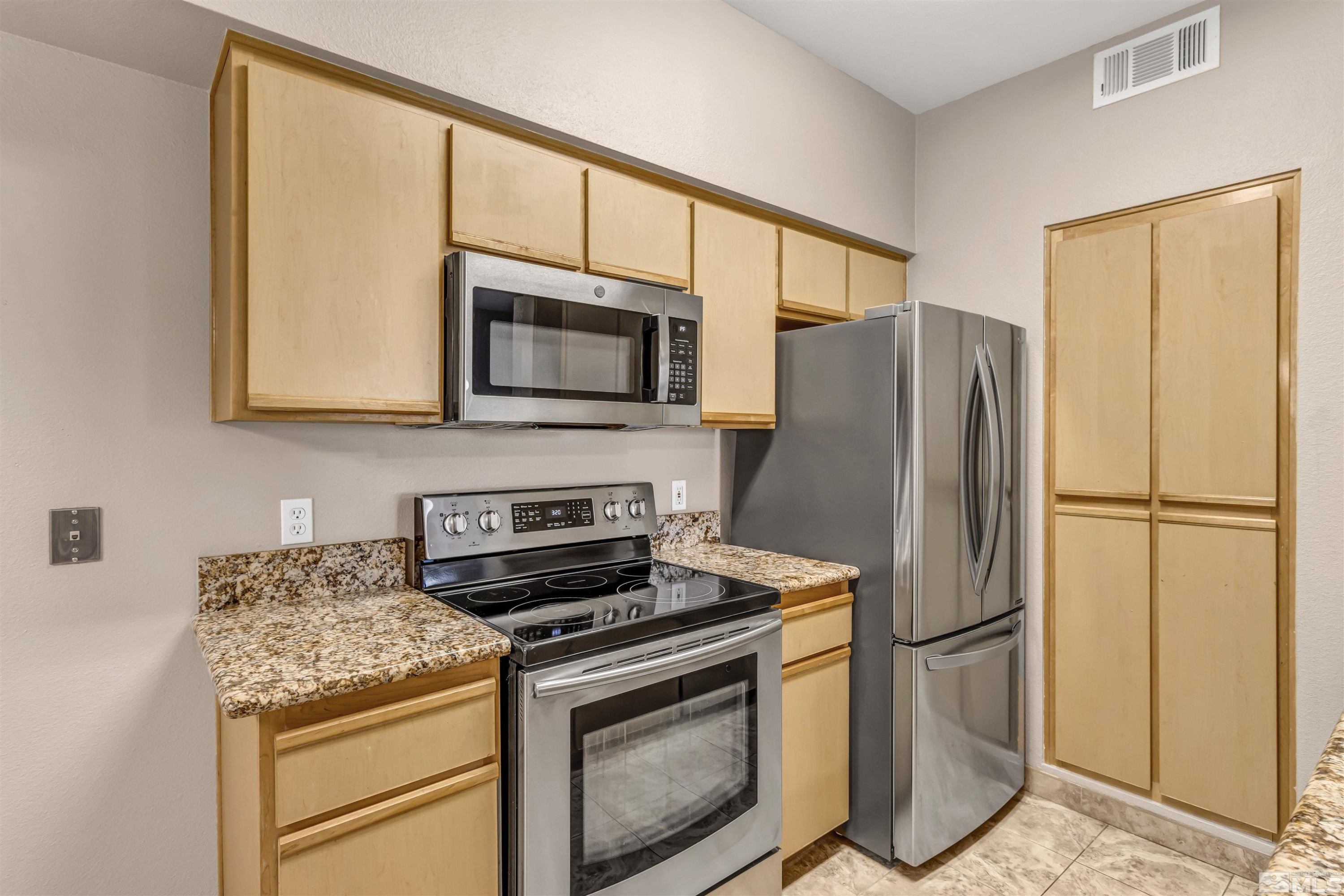 6850 Sharlands Avenue, Unit 1036 Reno, NV 89523 - Photo 8 of 36 a kitchen with a refrigerator stove and microwave