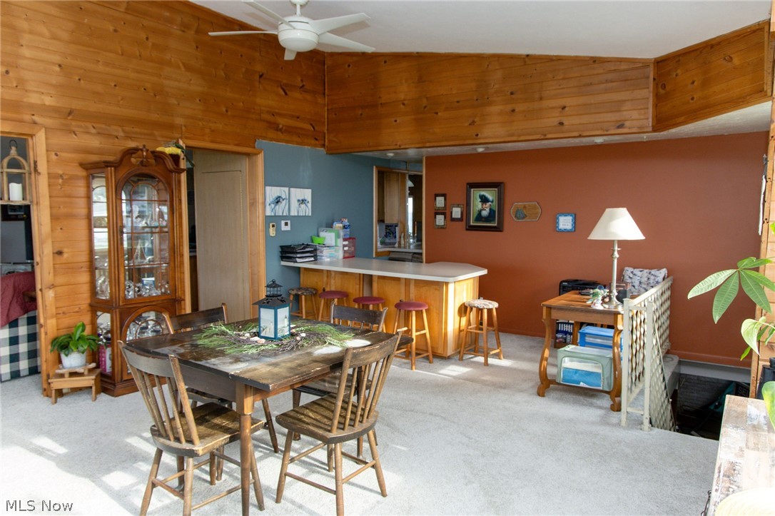 5467 Chapel Road Madison, OH 44057 - Photo 26 of 50 Open concept living area featuring a wood-paneled ceiling, light-toned carpeting, and a built-in breakfast bar with a light countertop