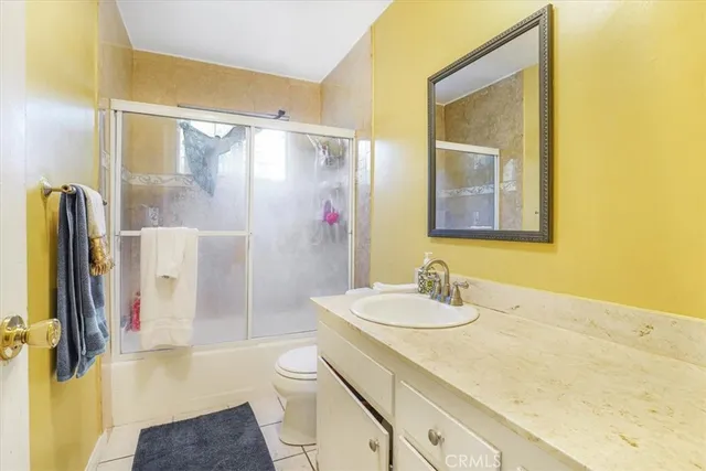 a bathroom with a granite countertop sink a mirror and shower