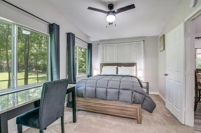 a bedroom with a bed chair and window