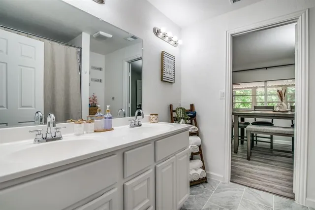 a en suite bathroom with a double vanity sink and a mirror