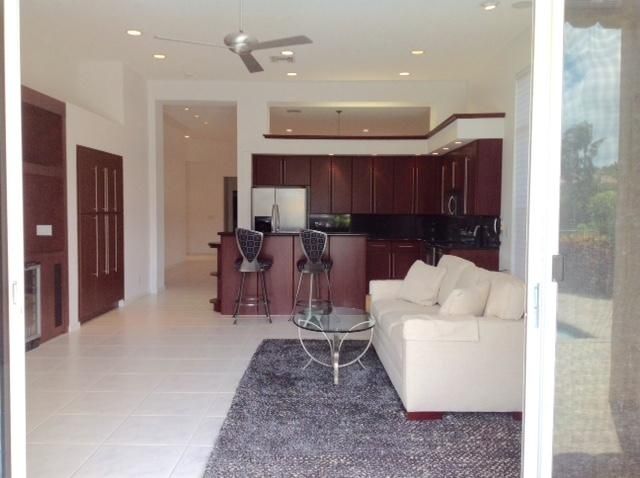a living room with furniture a wooden floor and kitchen view