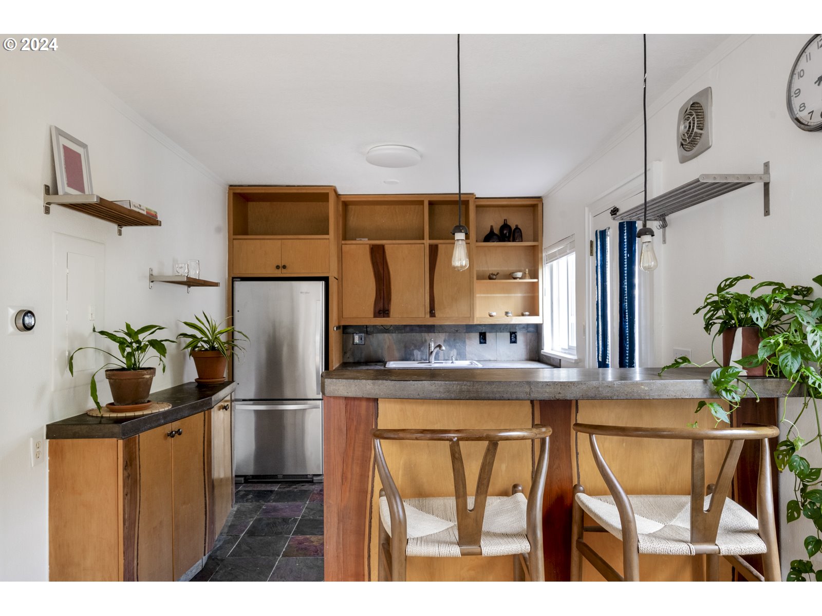 909 Northeast Brazee Street, Unit 17 Portland, OR 97212 - Photo 15 of 47 a kitchen with stainless steel appliances kitchen island granite countertop a refrigerator and a counter top space