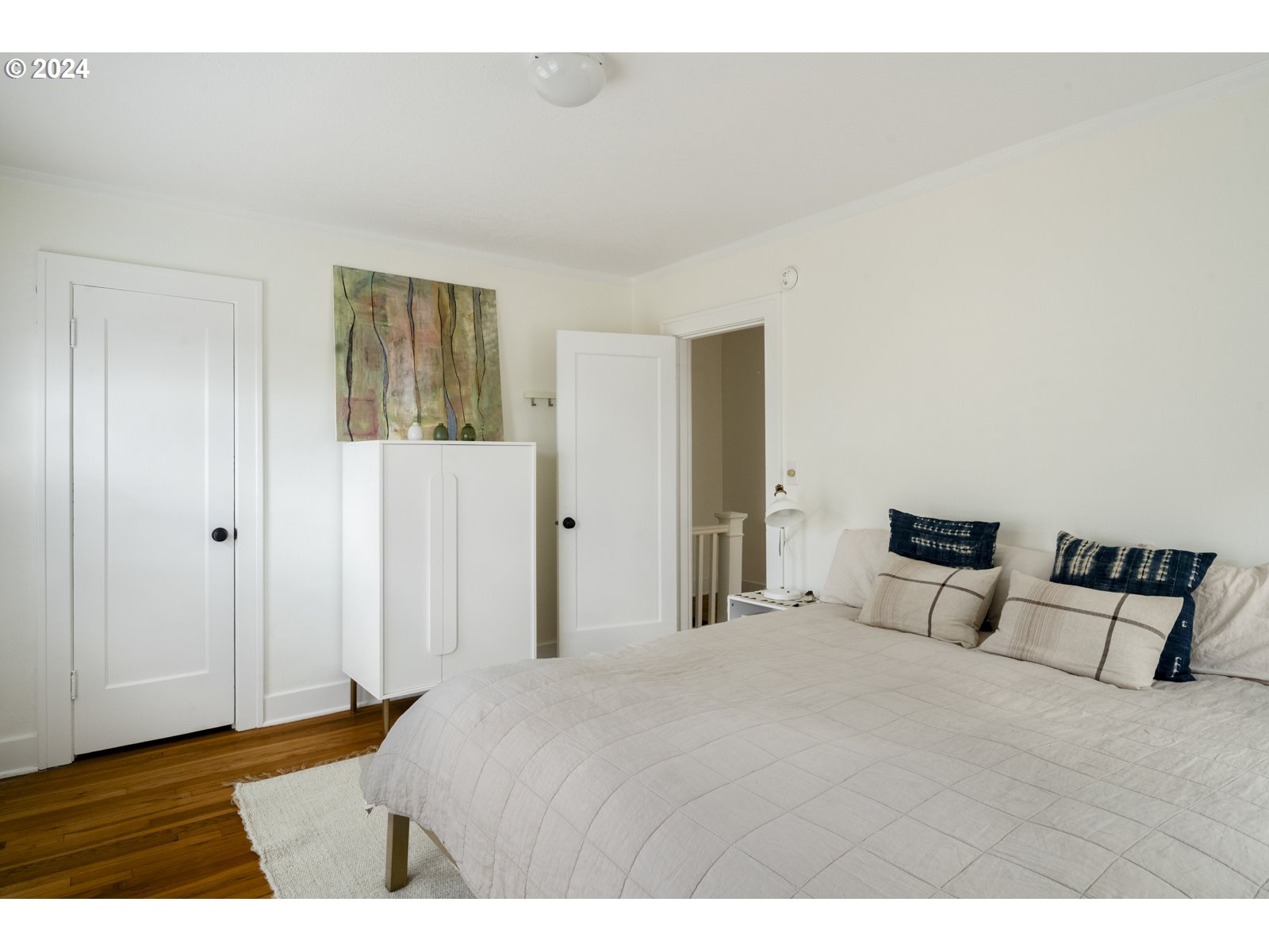 909 Northeast Brazee Street, Unit 17 Portland, OR 97212 - Photo 29 of 47 a bedroom with a bed and wooden floor