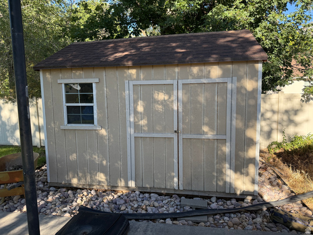 541 300 North Provo, UT 84606 - Photo 8 of 36 Exterior storage shed featuring a brown shingled roof, light-colored vertical siding, a single window, and double entry doors