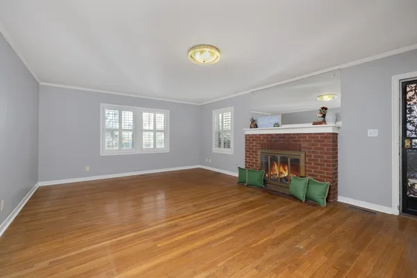 a view of empty room with wooden floor and fireplace