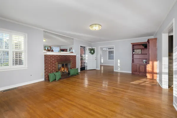a view of an empty room with window and wooden floor