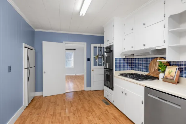 a kitchen with granite countertop white cabinets and white appliances