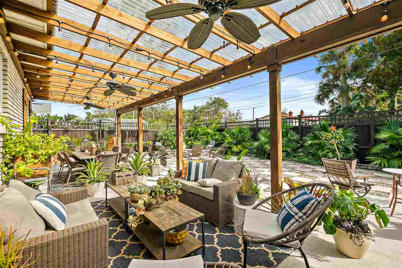 205 Oglethorpe Boulevard St. Augustine, FL 32080 - Photo 43 of 48 a view of a patio with table and chairs potted plants with wooden floor and fence