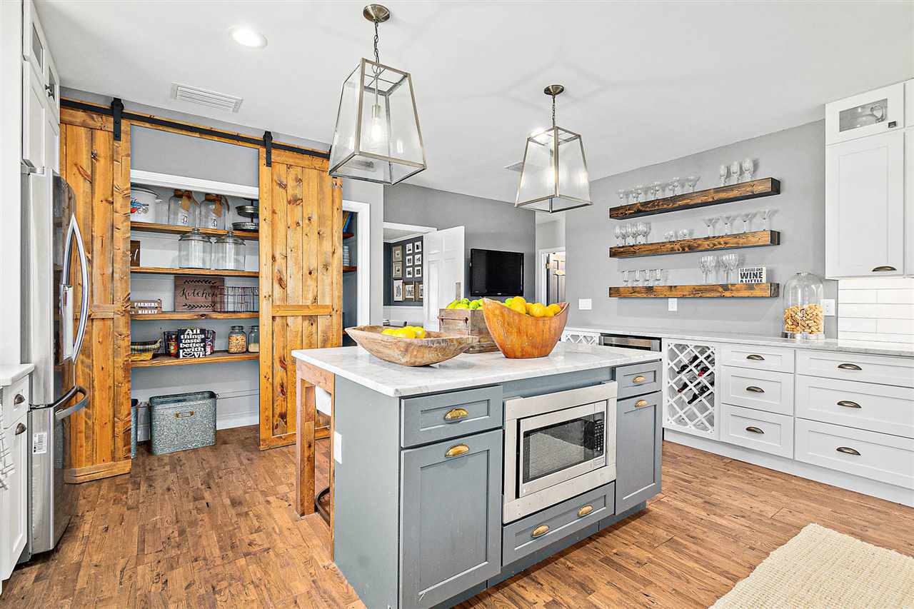 205 Oglethorpe Boulevard St. Augustine, FL 32080 - Photo 6 of 48 a kitchen with stainless steel appliances kitchen island granite countertop a stove a sink and a refrigerator
